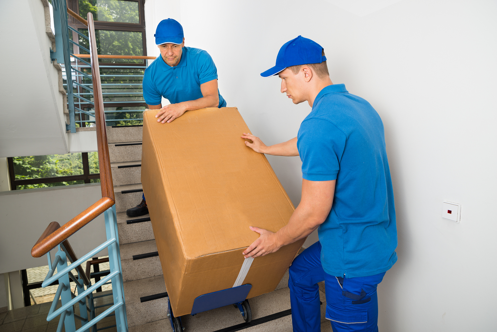 men moving a box down the stairs